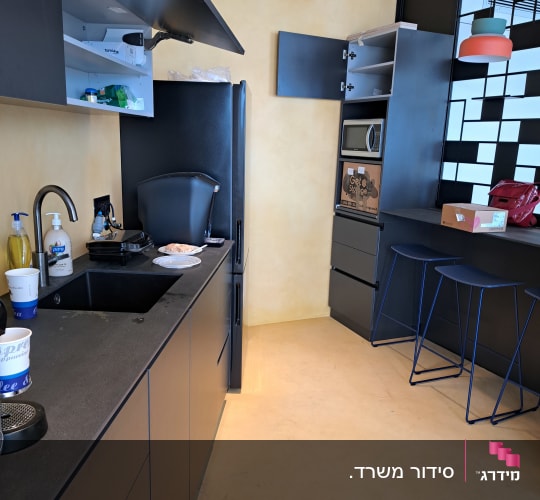 מטבח עם ארונות פתוחים, כיור וכלים על השיש